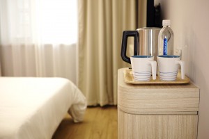 Hotel room with ameneties that include little more than water and coffee maker