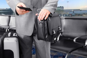 Business man uses business travel app at an airport